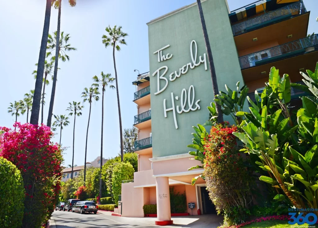 Beverly Hills landmark hotel sign surrounded by palm trees and luxury homes